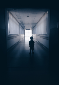 boy standing in creepy hallway
