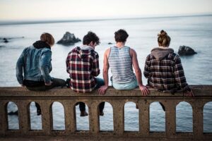 teen boys sitting by ocean